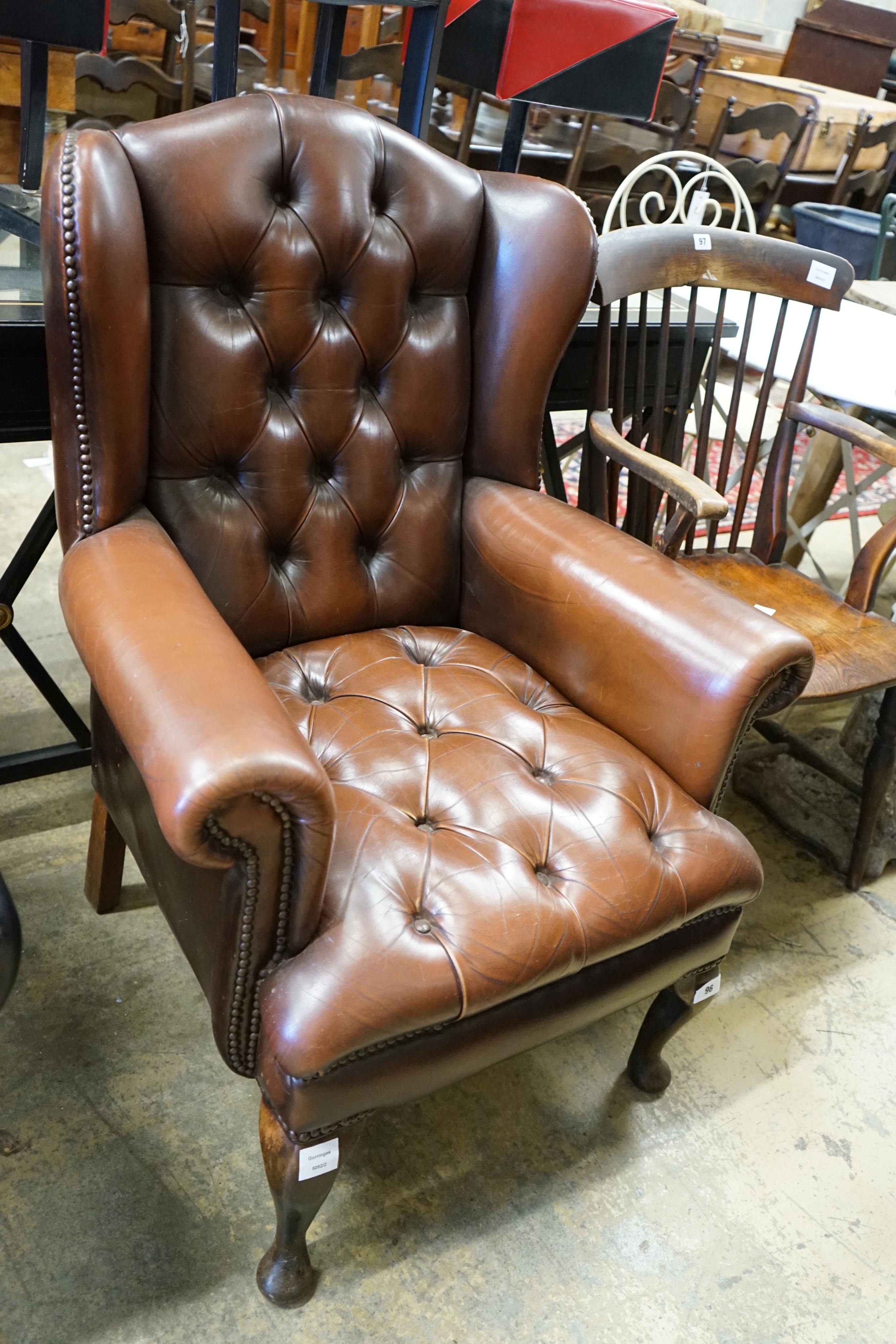 A Victorian style buttoned brown leather-upholstered wing armchair, width 77cm, depth 62cm, height 102cm